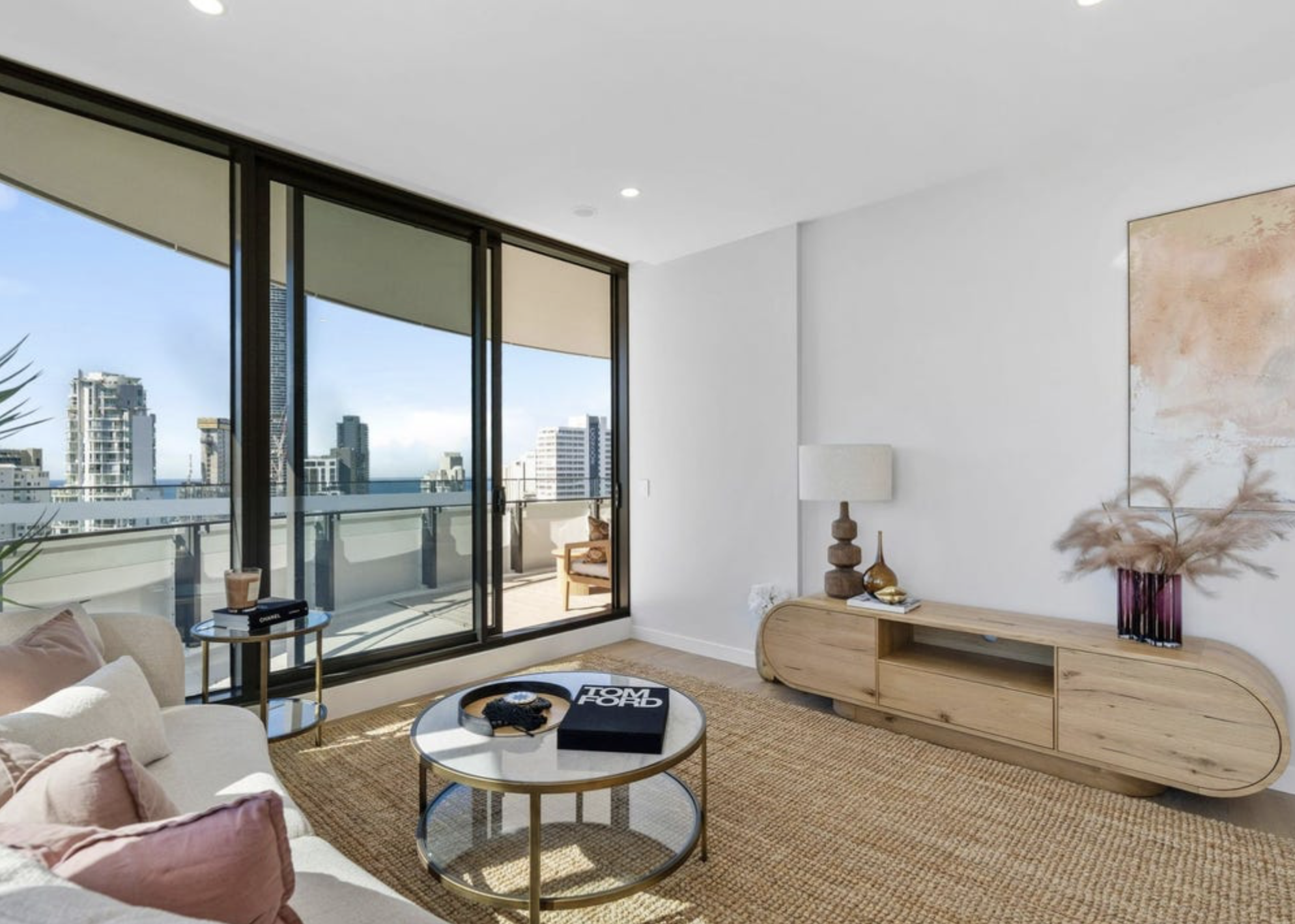 Second living space styled with jute rug, oak console and balcony outlook