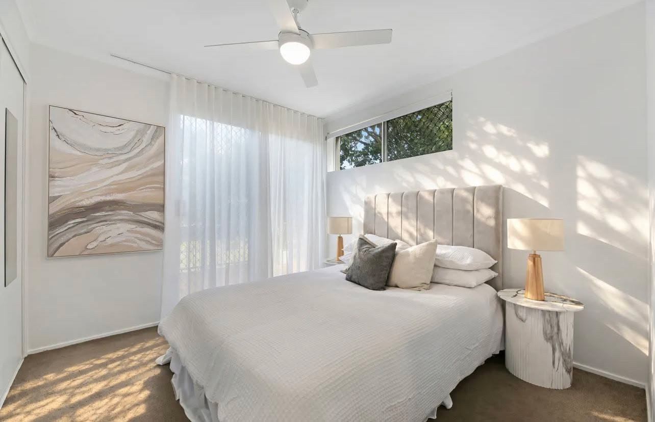 Third bedroom in soft neutrals with marble-look bedsides