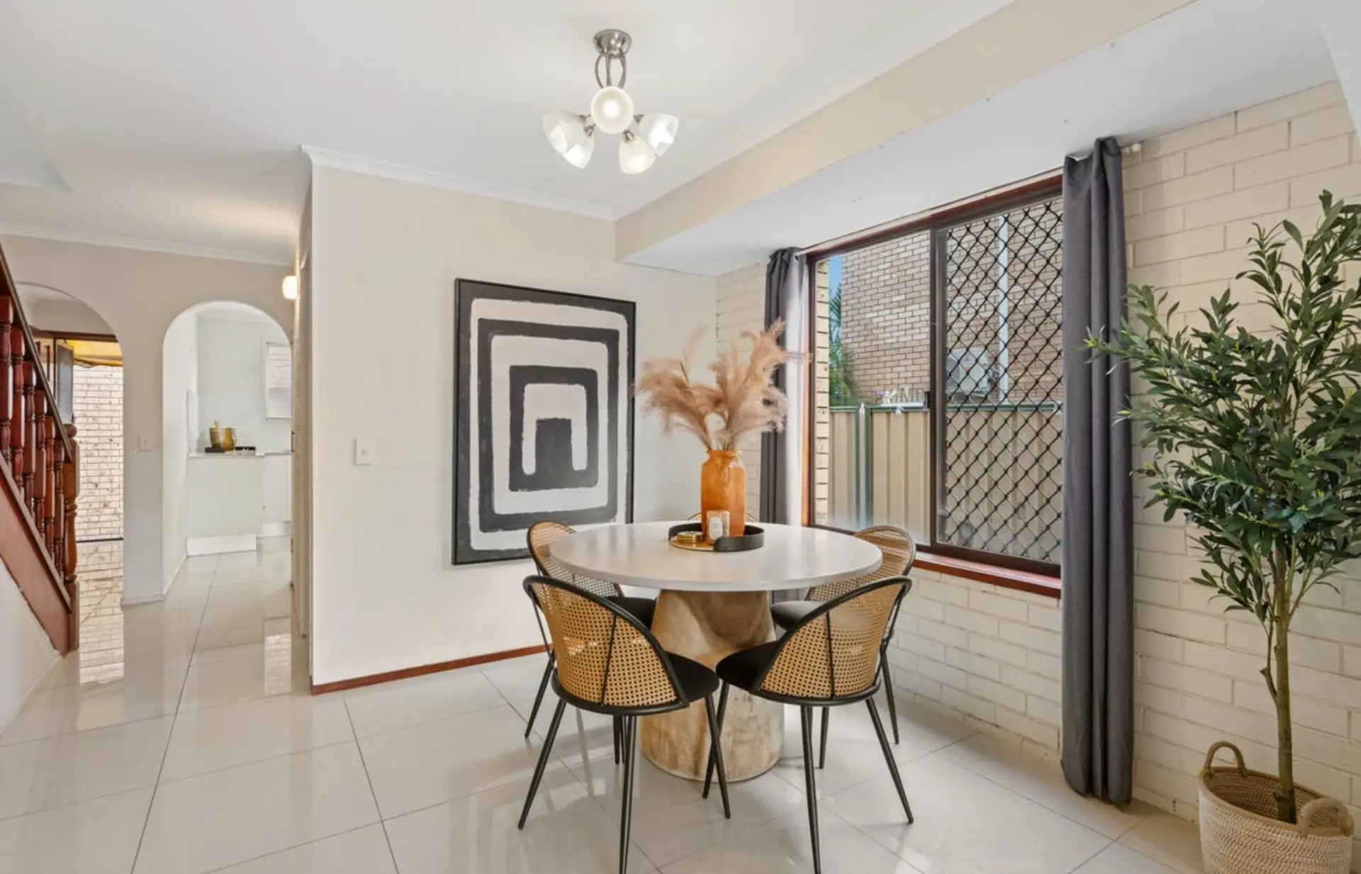 Dining nook styled with monochrome artwork and an olive tree