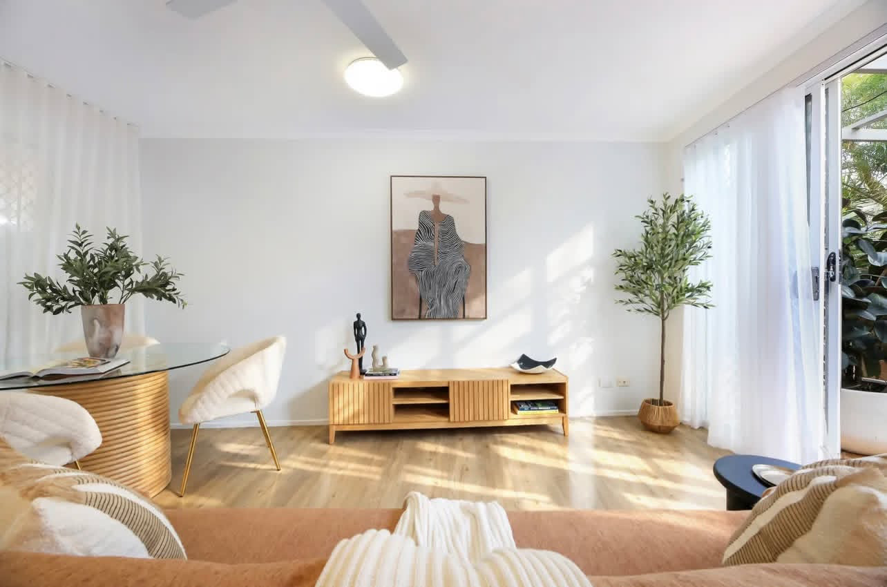 Dining area with glass-top cane table and framed figurative artwork