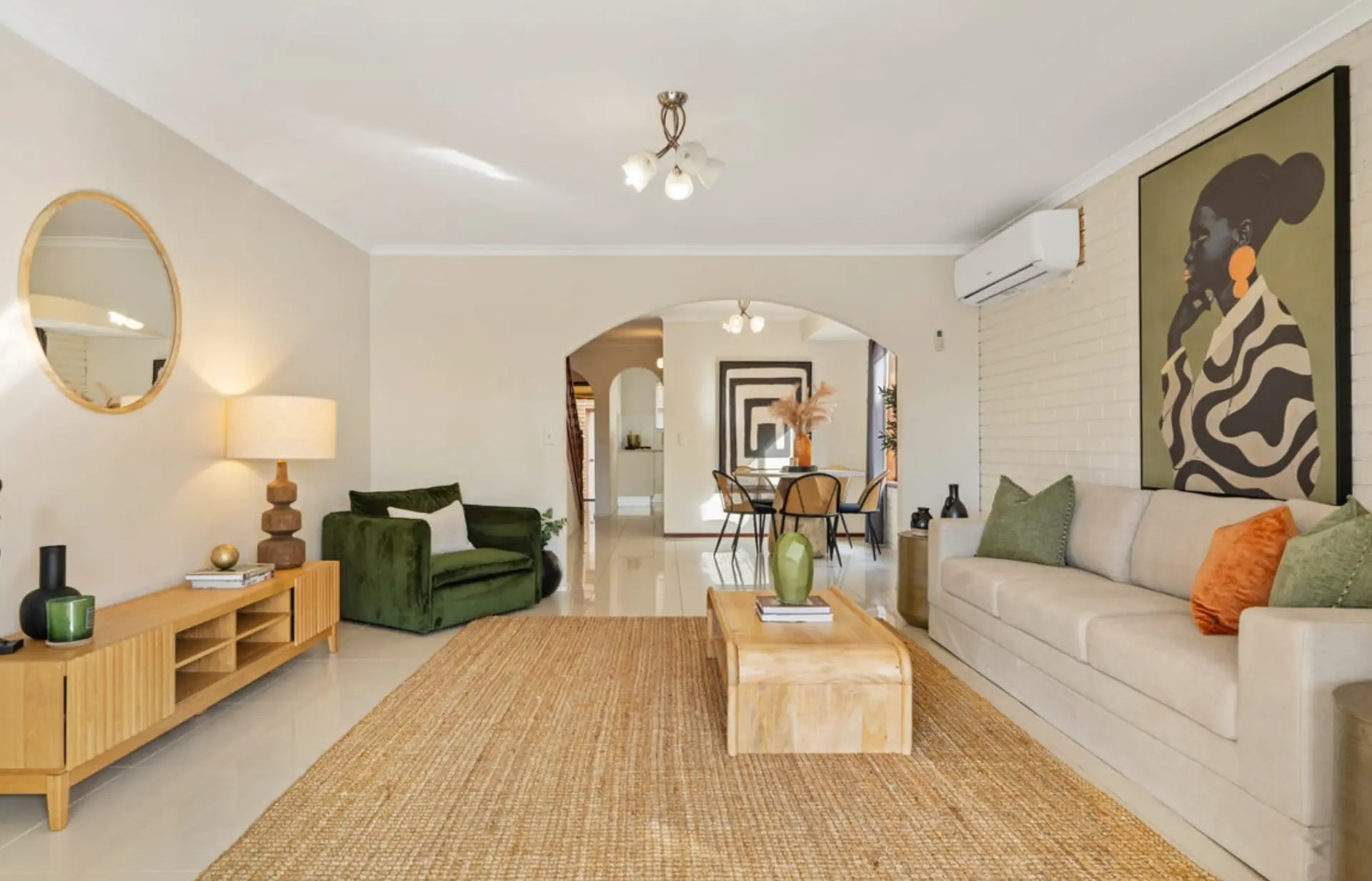 Second living area with green velvet armchair, oak console and jute rug
